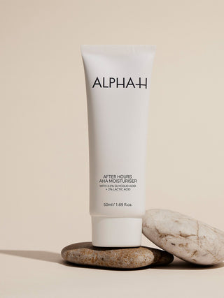 Alpha-H After Hours AHA Moisturiser sobre una pila de piedras