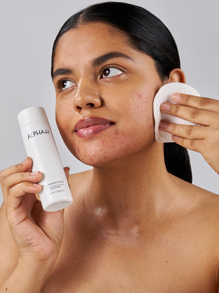 Alpha-H Clear Skin Tonic aplicación con disco de algodón