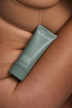 Alpha-H Daily Dose Multivitamin Body Serum tubo junto al brazo