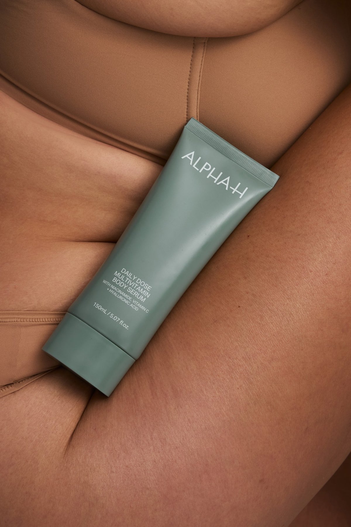Alpha-H Daily Dose Multivitamin Body Serum tubo junto al brazo