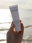 Alpha-H Daily Essential Moisturiser SPF50 tubo junto al mar