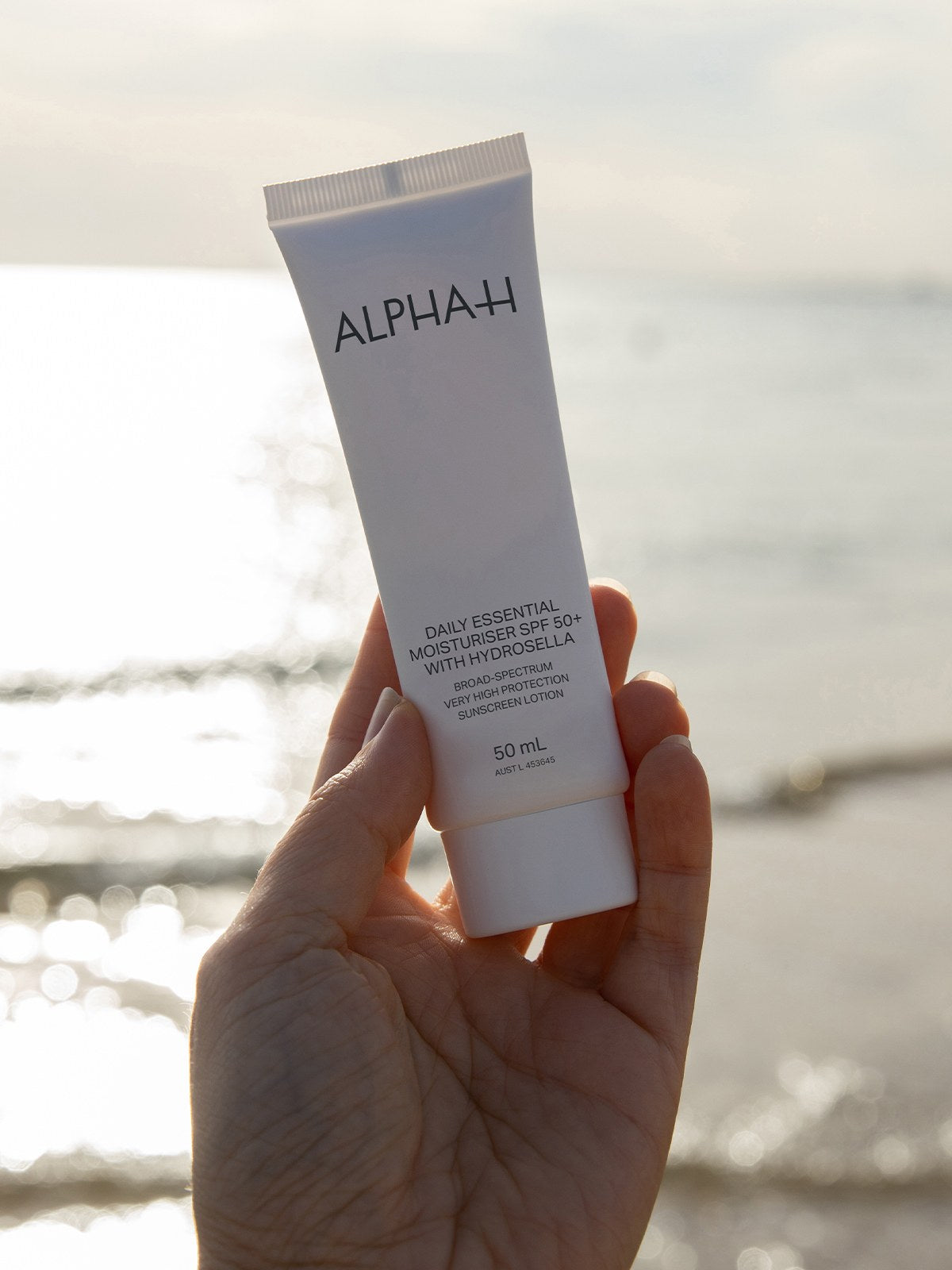 Alpha-H Daily Essential Moisturiser SPF50 tubo junto al mar
