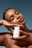 Alpha-H Liquid Gold Exfoliating Treatment modelo con el frasco a la luz del sol