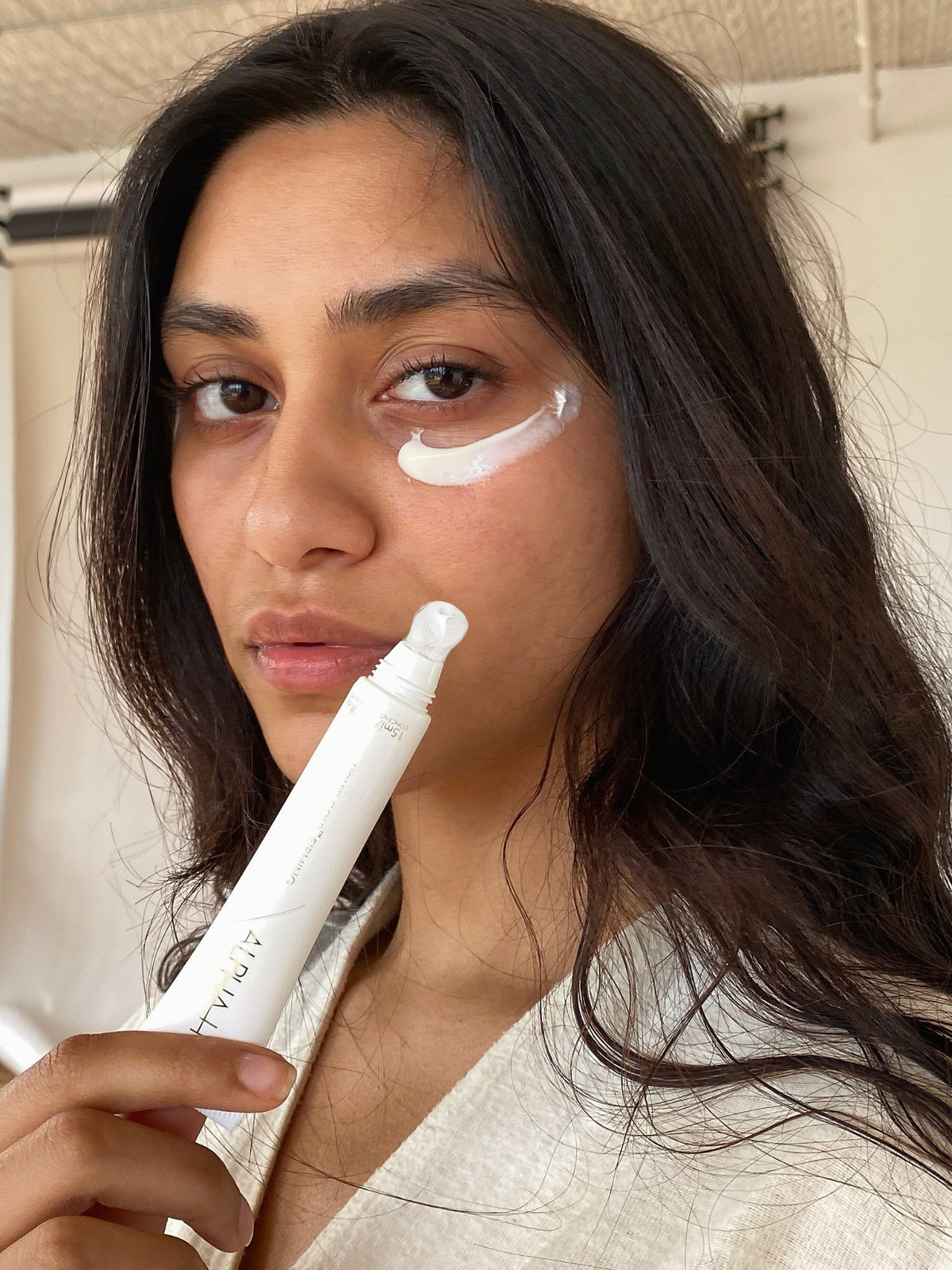 Alpha-H Liquid Gold Firming Eye Cream modelo con el tubo