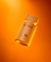 Alpha-H Liquid Gold + Vitamin C Exfoliating Treatment frasco con luz naranja