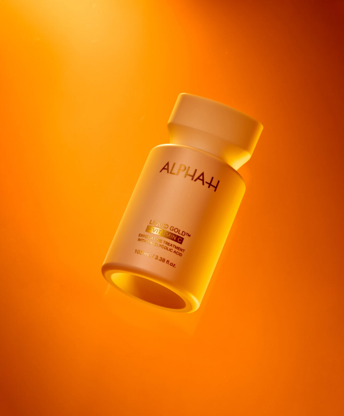 Alpha-H Liquid Gold + Vitamin C Exfoliating Treatment frasco con luz naranja