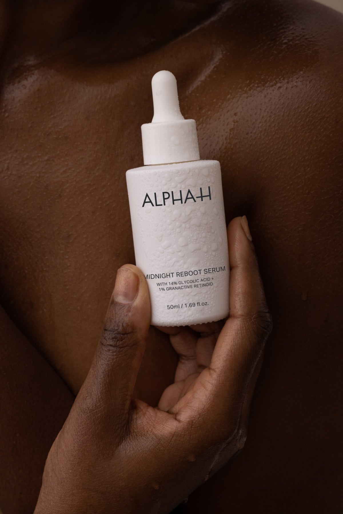 Alpha-H Midnight Reboot Serum frasco en la mano