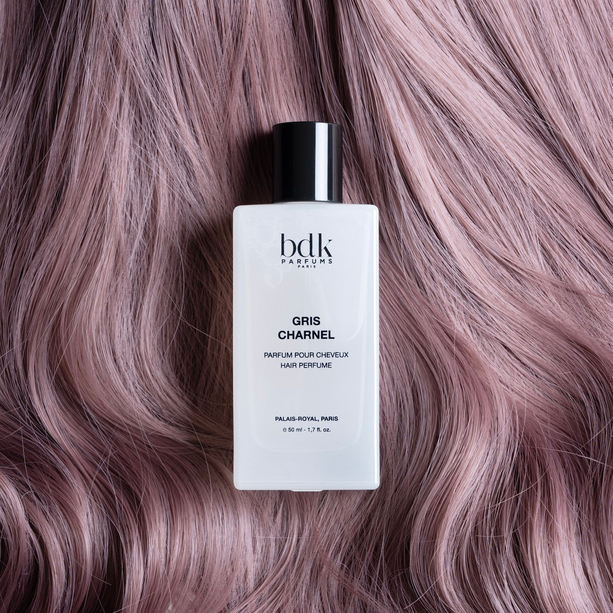 BDK Parfums Hair Perfume Gris Charnel frasco sobre cabello lila