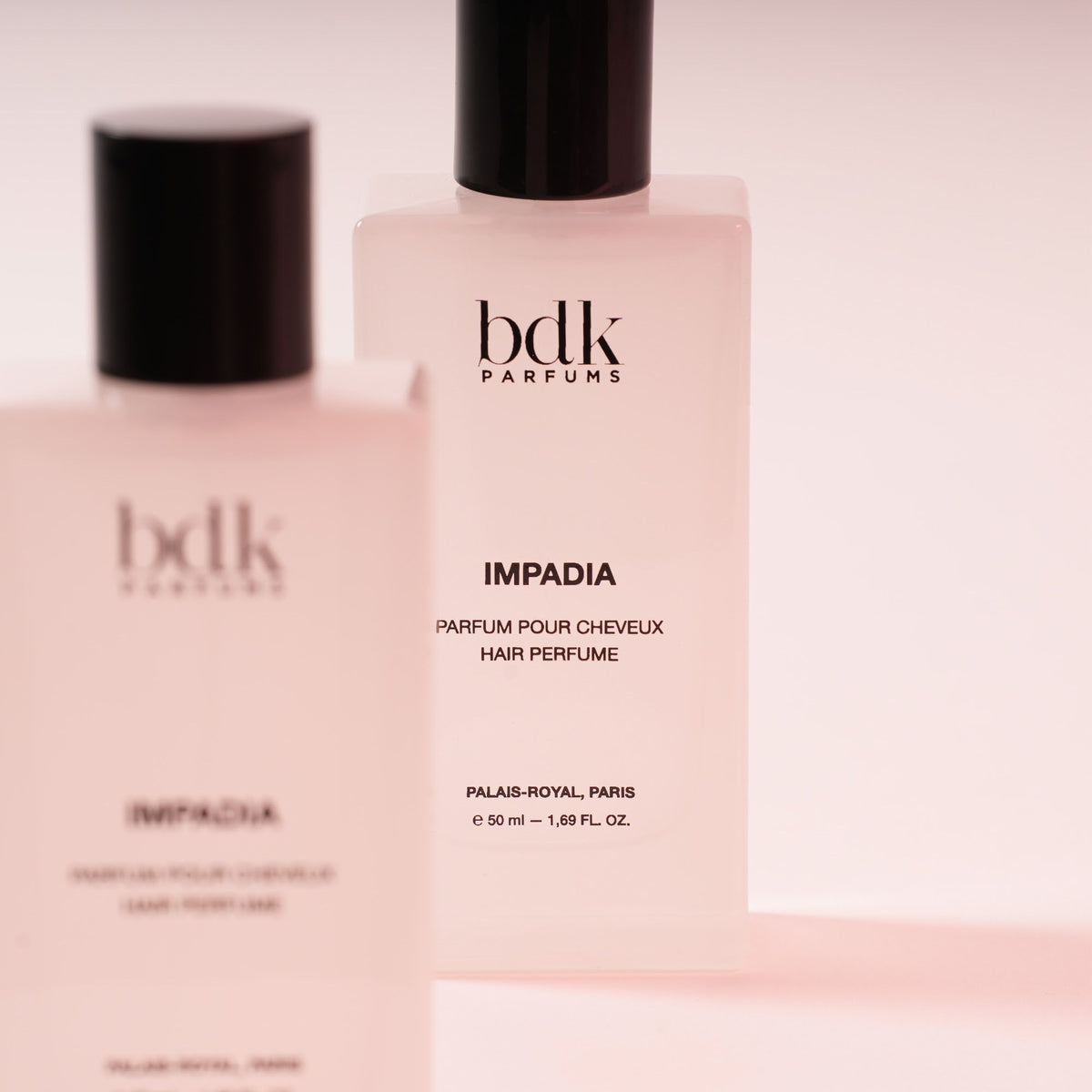 BDK Parfums Hair Perfume Impadia primer plano de dos frascos sobre fondo rosa