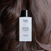 BDK Parfums Hair Perfume Pas Ce Soir frasco sobre cabello castaño oscuro