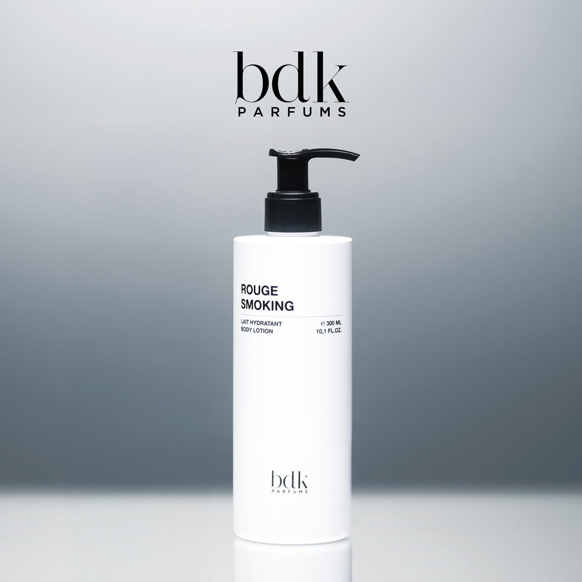 BDK Parfums Rouge Smoking Body Lotion frasco con dosificador en estudio con logo bdk