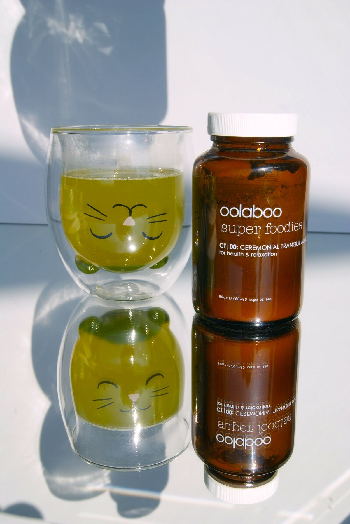 Oolaboo Super Foodies Ceremonial Tranquil Tea con un vaso de té