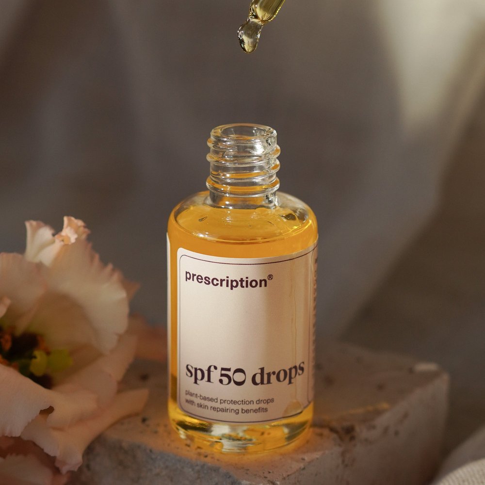 Prescription SPF50 Drops 30ml open flacon met pipet en bloemen